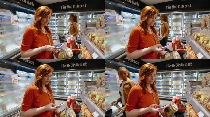 一名妇女在超市购买杂货时使用手机