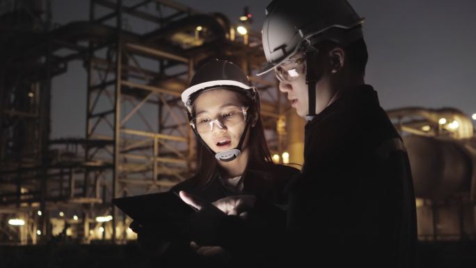 石油和天然气工业中的炼油厂工程师工人使用个人安全设备PPE进行检查，并遵循平板检查表。