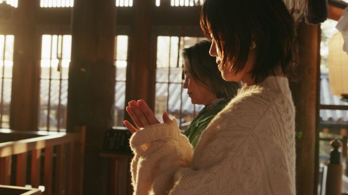MCU-一位年长的妇女和她的女儿在日本寺庙为Hatsumode祈祷