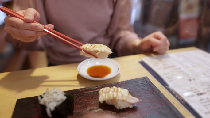 在日本餐厅吃寿司的女人