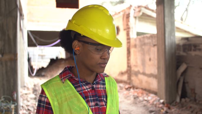 现场戴着防护耳塞的非洲女建筑工人