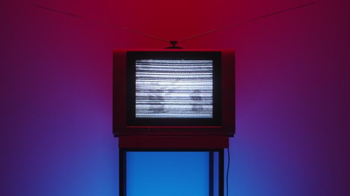 在红色和紫色渐变的背景上，框架中间有电视静态噪声的旧电视