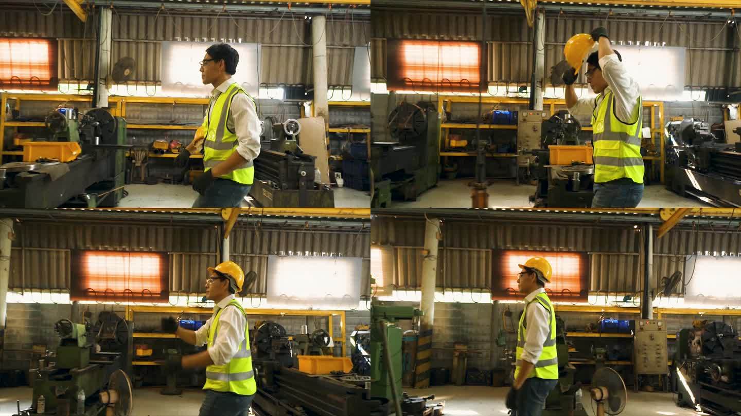 工程师们正在为工业工人使用机器。戴着安全帽和反光背心的亚洲男女工人在工厂工作。侧视慢动作场景：工厂里