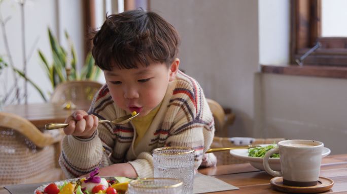 小男孩正在吃沙拉童年悠闲随意