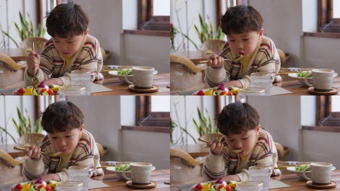 小男孩正在吃沙拉童年悠闲随意