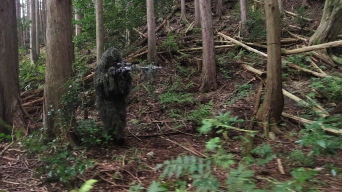 穿着吉莉套装的狙击手在森林里跟踪