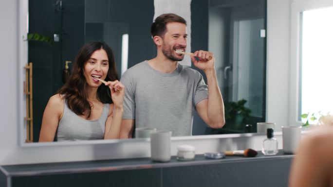 一对刷牙的夫妇热恋情侣家庭浴室间早起刷牙