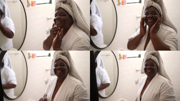 一位快乐的老年妇女在家里给脸上涂抹面部保湿剂的肖像