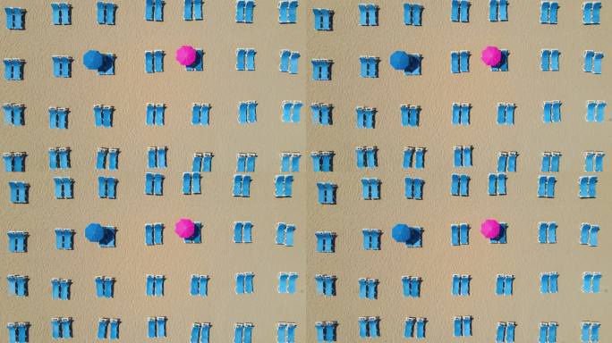 空沙滩上的空沙滩伞，4K分辨率，躺椅和海景的鸟瞰图，日光躺椅伞，沙滩上的日光躺椅和雨伞，空沙滩和空日