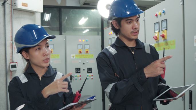 电工工程师在工业工厂的控制室、操作员站网络中工作、检查和记录电气保护继电器参数。