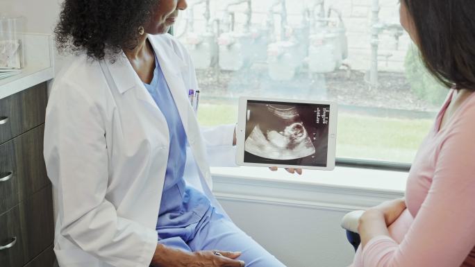 孕妇和医生检查超声图像