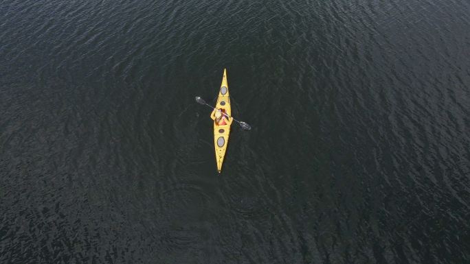 高山湖泊中女子皮划艇的鸟瞰图。划船和生态旅游。