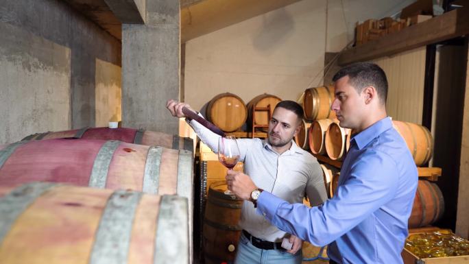 酒庄老板和质量控制专家正在检查酒窖中的葡萄酒质量