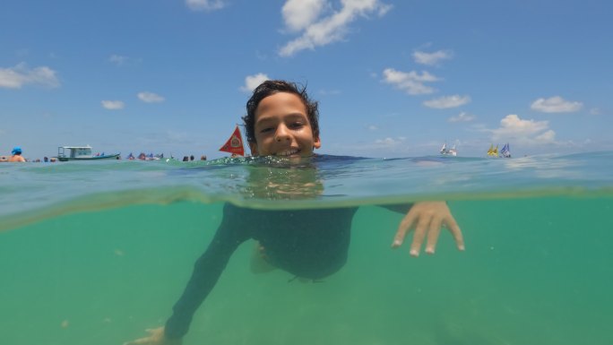 在海里游泳的孩子度假国外男孩学习游泳海边