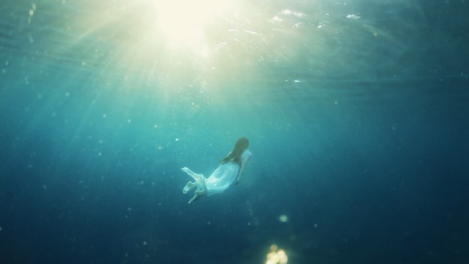 SLO-MO白裙女子在水下游泳