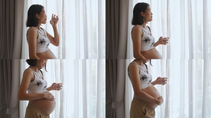 亚洲孕妇拿着一杯水