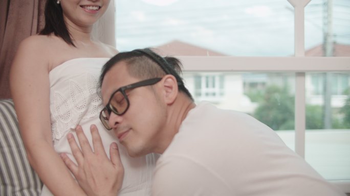一对怀孕的亚洲夫妇和她的丈夫在一起玩得很开心