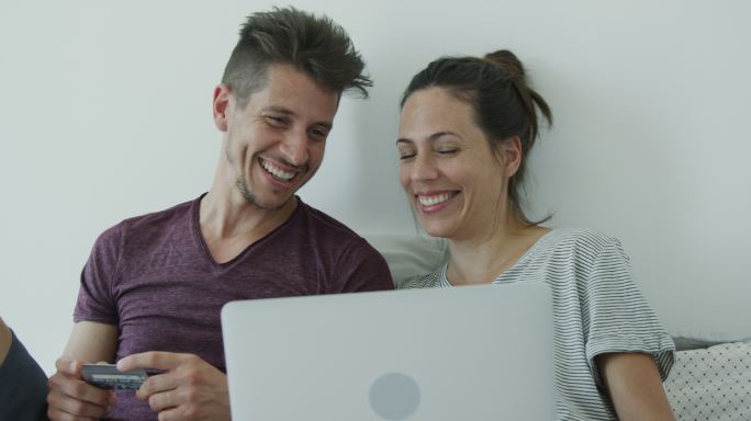 年轻夫妇使用笔记本电脑在线购物