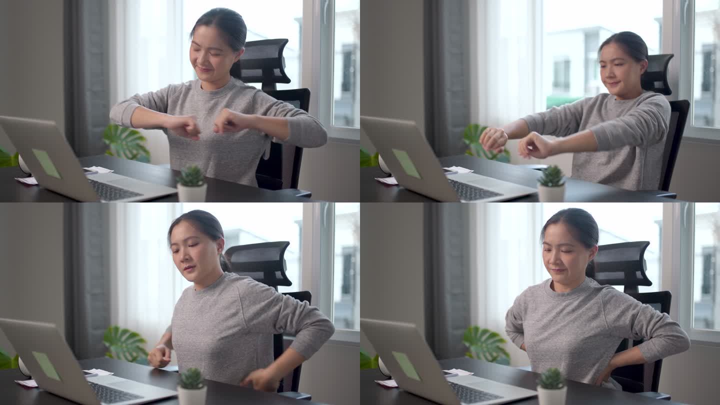 一名在家庭办公室用笔记本电脑工作的亚洲妇女身体疼痛。