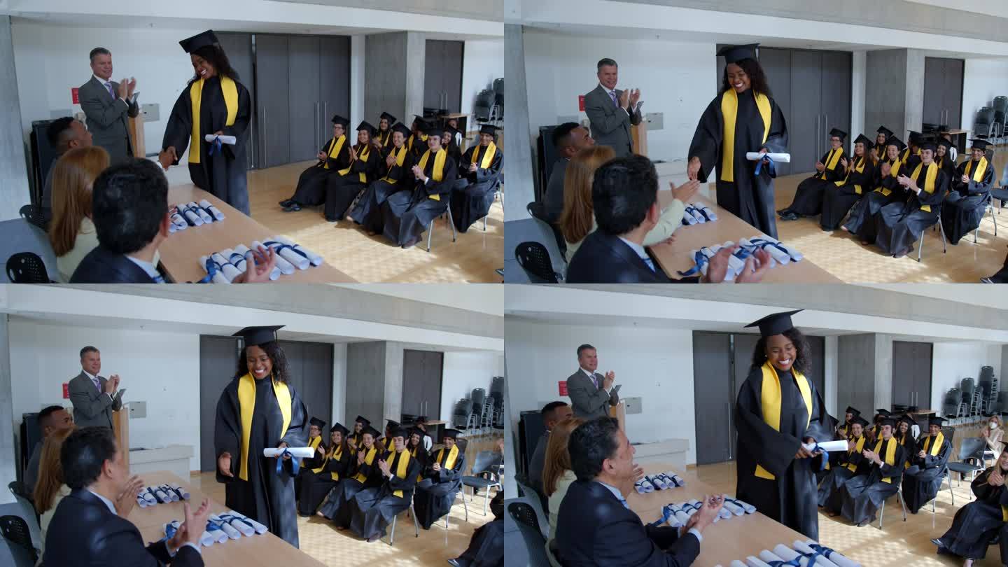 快乐的非洲裔美国女毕业生，收到毕业证书并和老师和院长握手