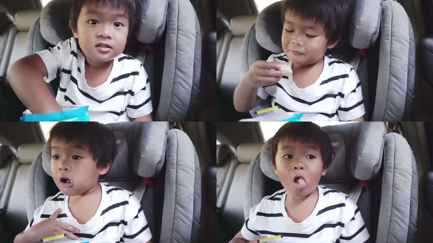小男孩坐在汽车座椅上吃零食