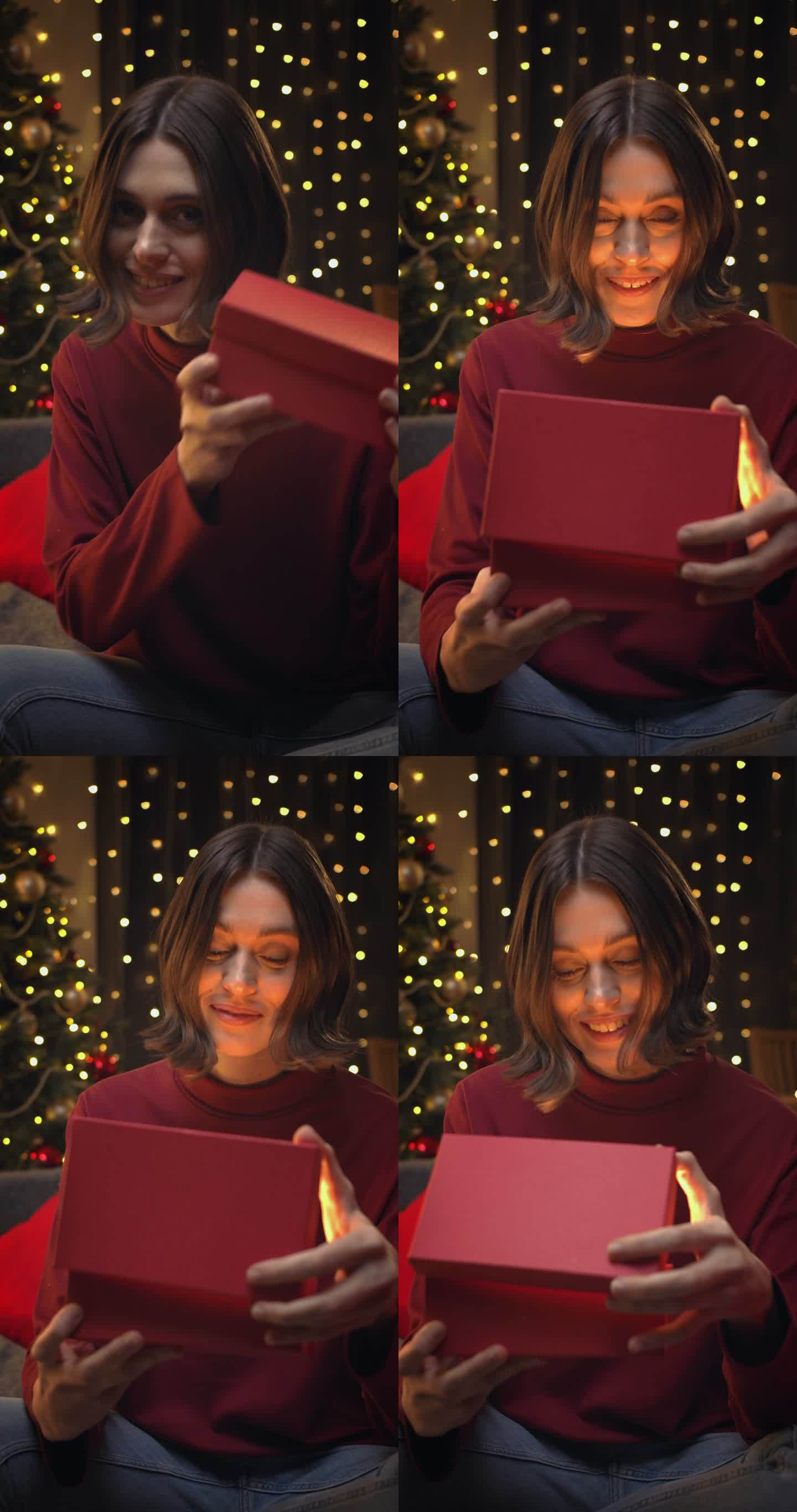 一个棕色头发的年轻漂亮女人打开一个礼物盒的特写镜头，背景是圣诞灯