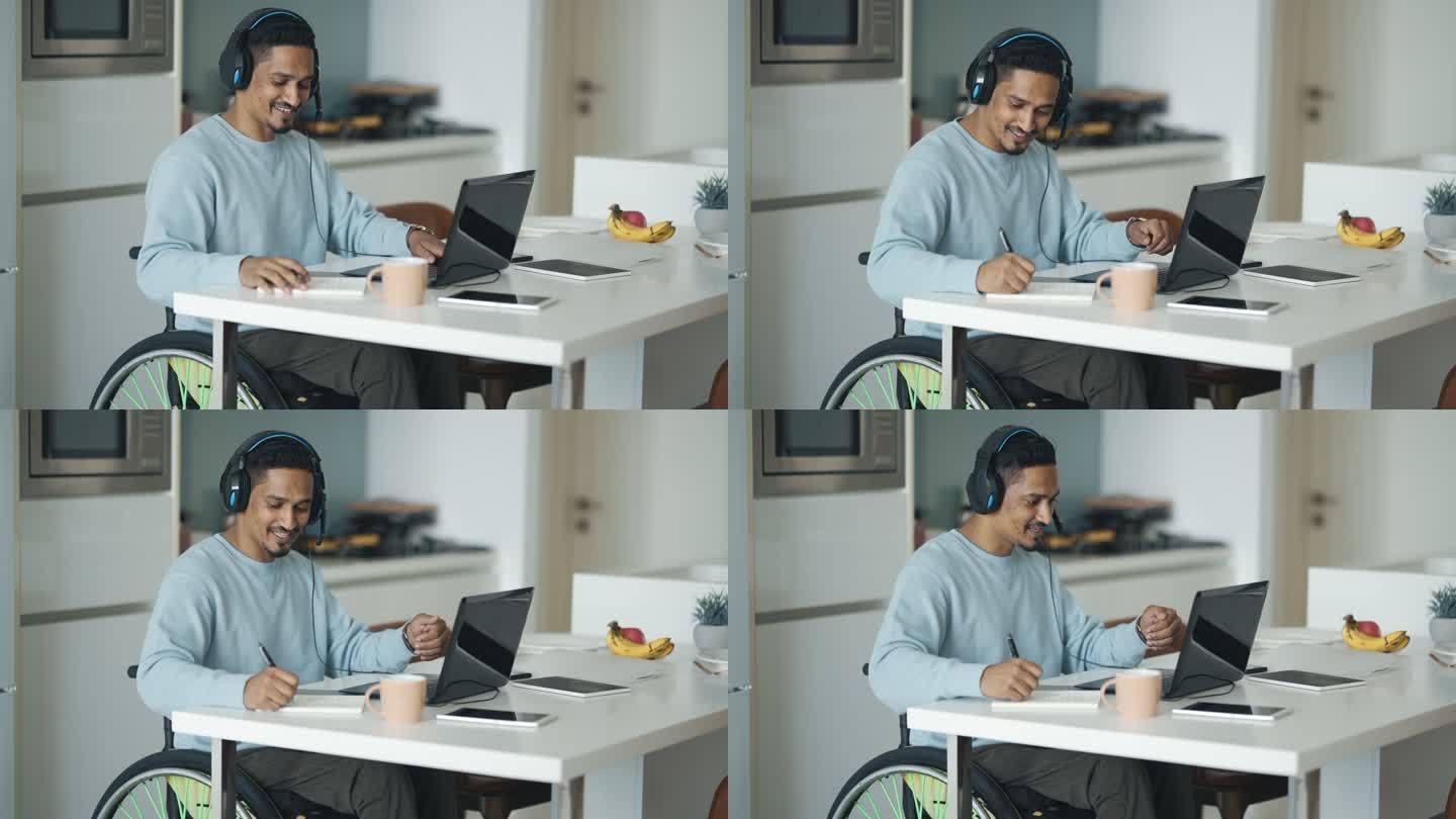亚洲印度残疾人坐在餐厅的轮椅上，用笔记本电脑进行视频通话