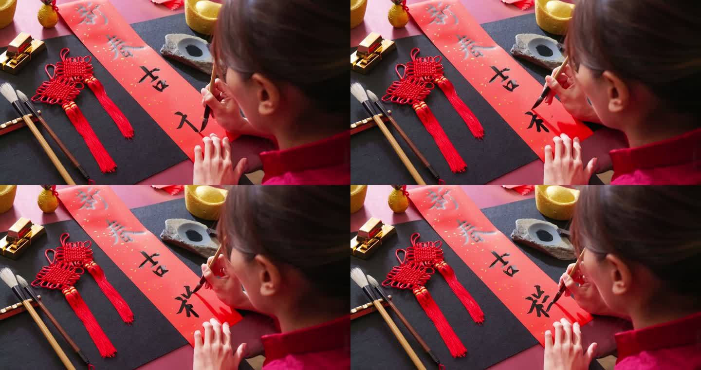 写春联女子写对联中国传统春节中华民族文化