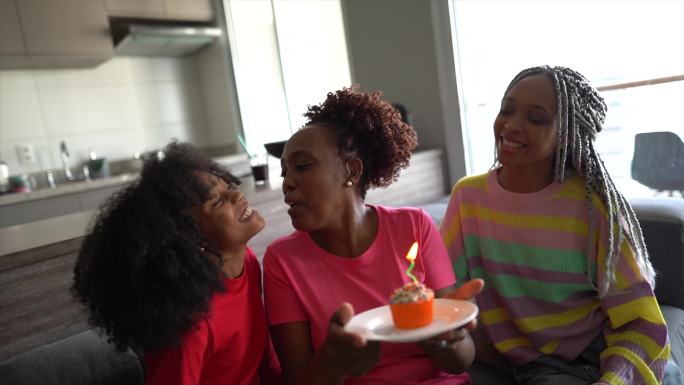女儿们在家里用纸杯蛋糕庆祝母亲的生日