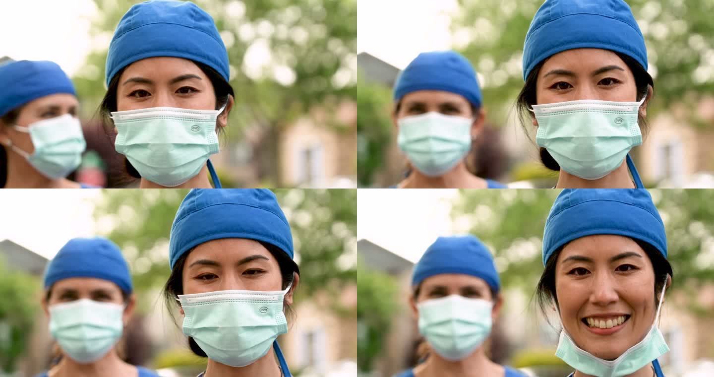 微笑的亚裔和高加索人医护人员戴着防护面罩