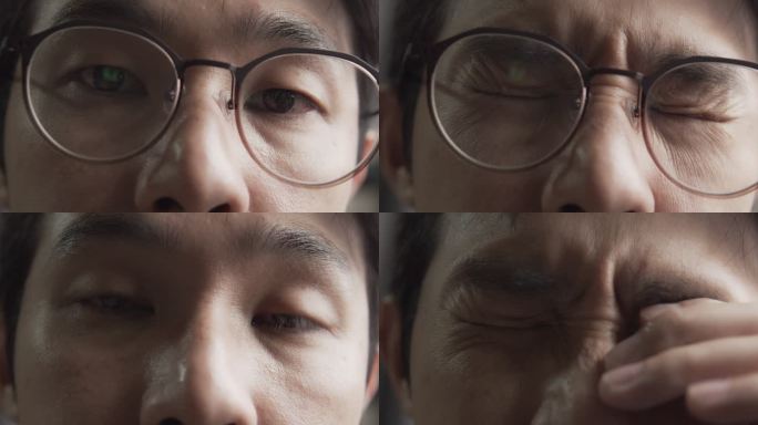 一名戴眼镜的亚裔男子，由于在电脑上工作而感到压力或抑郁，眼睛疲劳。用电脑工作到很晚