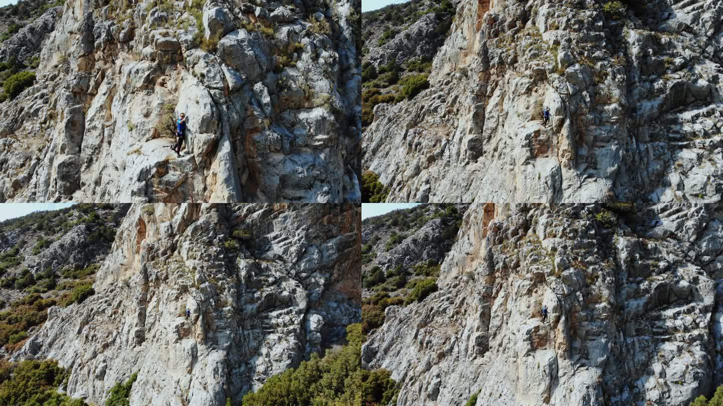 高山女攀岩者正在攀登山顶的鸟瞰图