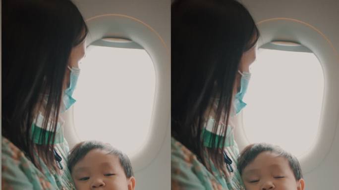 坐飞机旅行时，男孩睡在母亲的怀里。