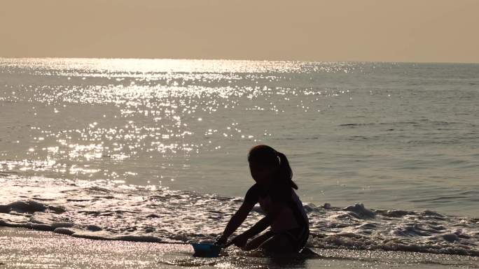 海边沙滩黄昏周末小女孩小男孩在玩水