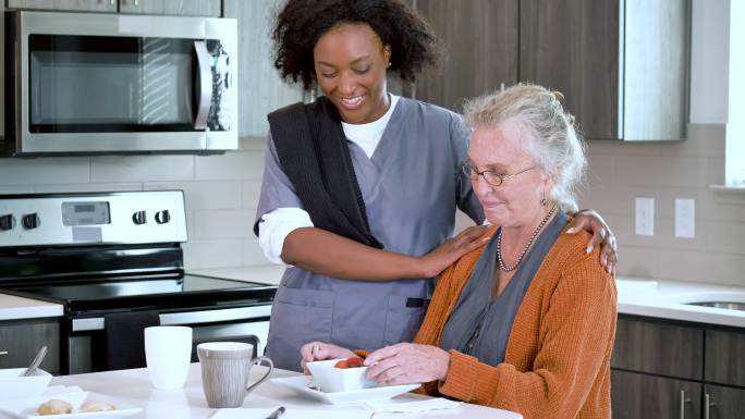 家庭护理员帮助老年妇女吃健康零食