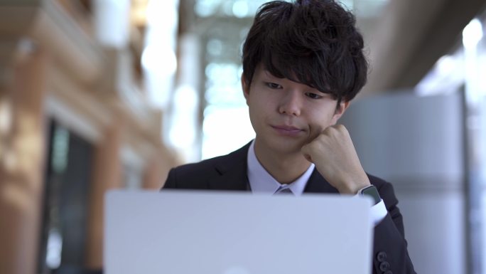 一个亚洲男人正在使用笔记本电脑，