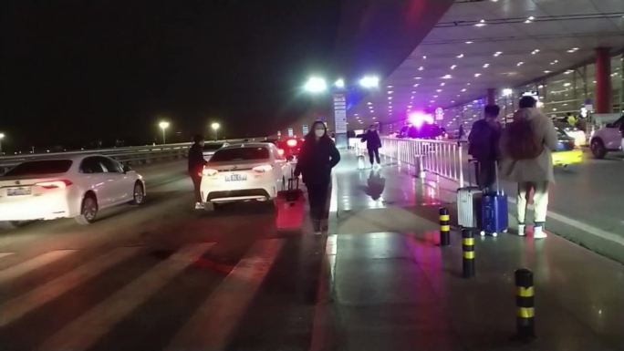 夜晚首都机场入口出租车旅客下车走入机场