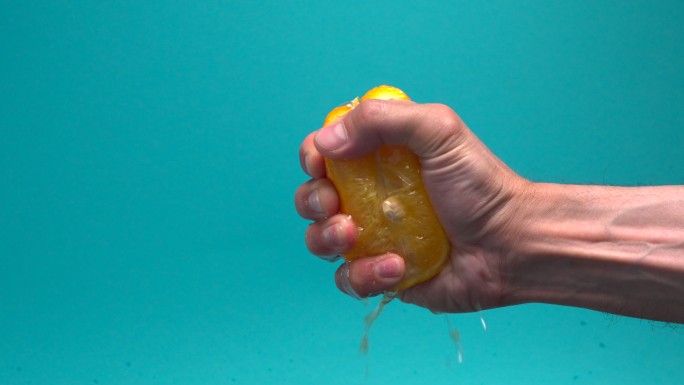 男性的手挤压橘子水分含水量手劲