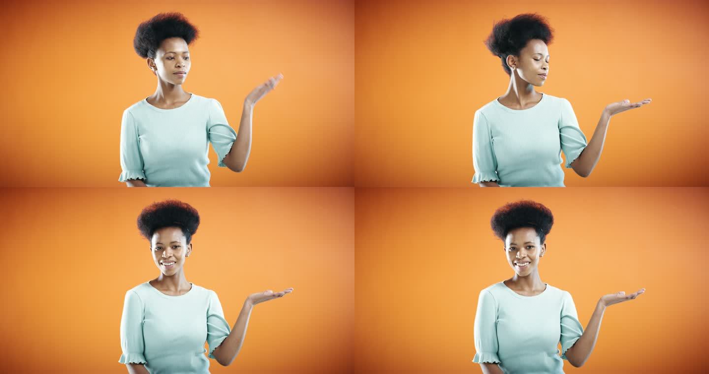 一位年轻女子在橙色背景下展示复制空间。混血女性用手做手势，在工作室背景中隔离