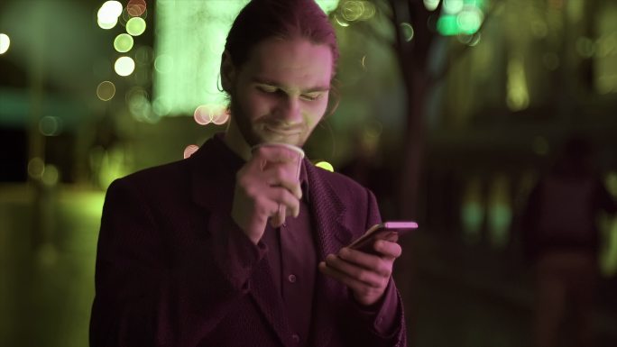 城市街道夜间文本外国男子看手机刷手机