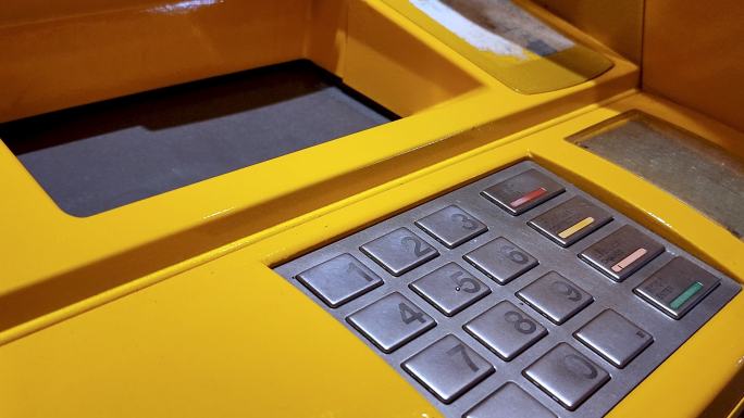一只手将现金插入自动存款机纸币接收器的特写