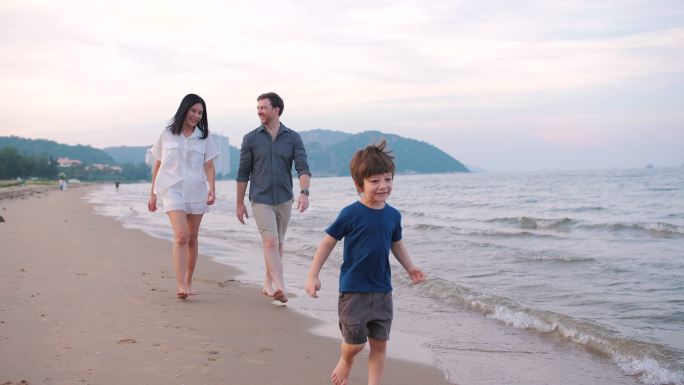一半的美国家庭在日落海滩散步。