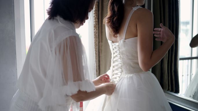 裁缝正在测量身体周围的尺寸，试穿婚纱。