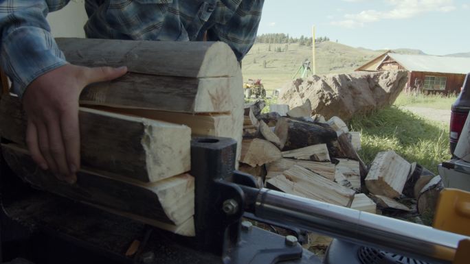科罗拉多州泰勒里德附近山区的家庭牧场上，年轻的兄弟们正在做家务，用液压瓦斯劈柴机劈柴