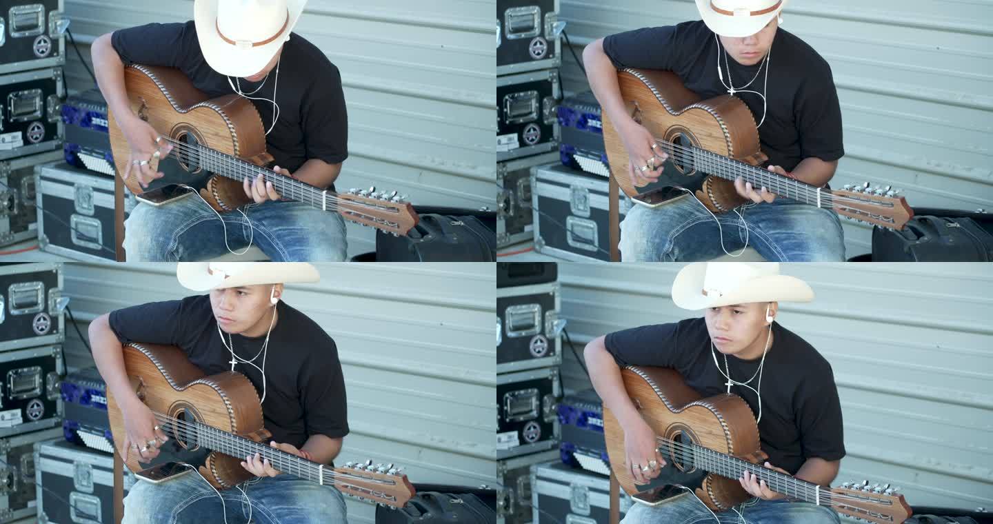 十几岁的西班牙男孩戴着牛仔帽弹吉他