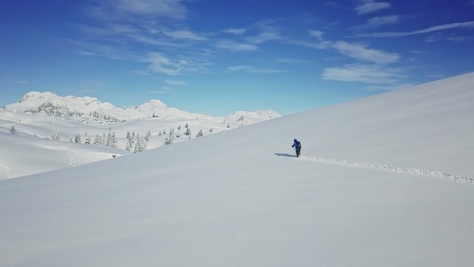 无人机：在卡姆尼克-萨文亚阿尔卑斯山，一名无法辨认的徒步旅行者在新鲜的雪中跋涉