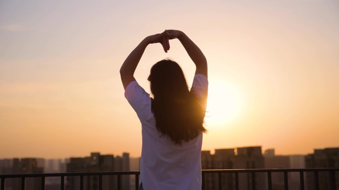 头部制作心形女孩面向夕阳背影爱心天台女性