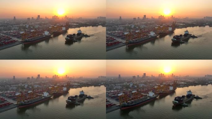 在泰国曼谷日出的场景中，无人机拍摄了一艘货船停靠在码头上，起重机吊杆下降到位，卸下集装箱