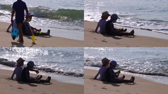海边沙滩小女孩小男孩坐在沙滩晒太阳