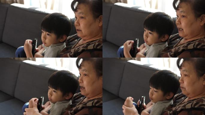 快乐的小男孩和奶奶在家看电视